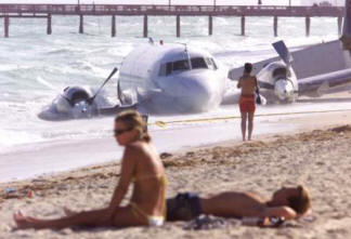 on beach with wrecked plane